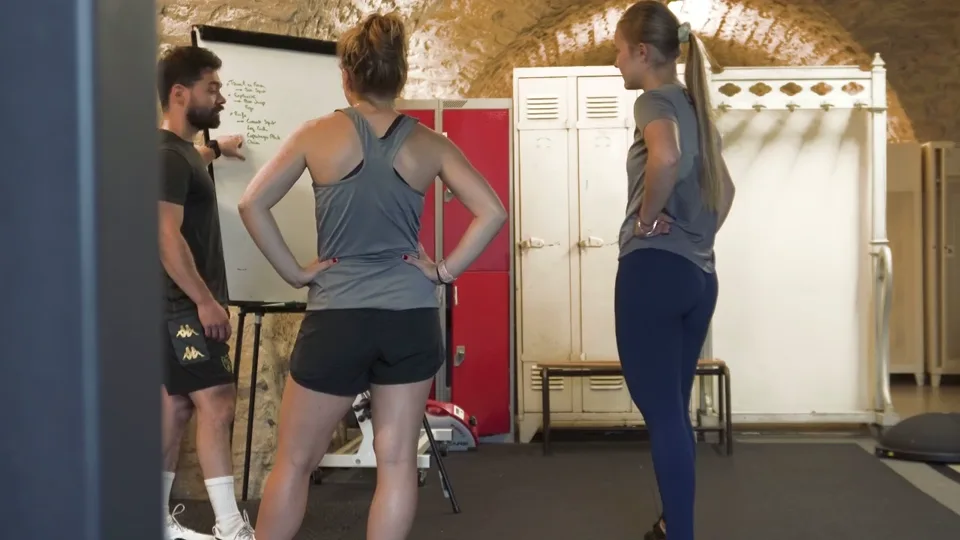 Votre coach présente les mouvements à deux participantes dans le studio